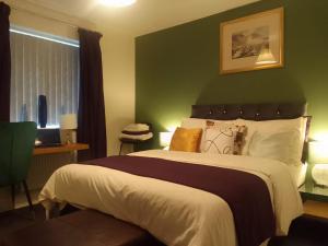 En eller flere senge i et værelse på 10 Guests - Garden - Quiet Retreat Cottage