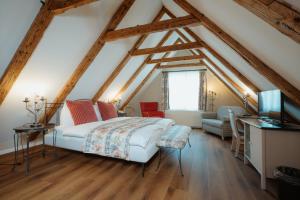 een slaapkamer op zolder met een bed en een bank bij Parkhotel Schwert in Weesen +150 foto's