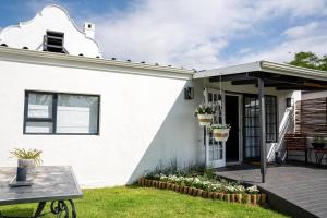 Casa blanca con patio y mesa en Faraway Cottage 3 Gables Self catering Swellendam, en Swellendam