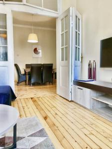 un soggiorno con pavimento in legno e tavolo di Charming Apartment Sofia 100m² a Sofia