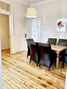 una sala da pranzo con tavolo in legno e sedie nere di Charming Apartment Sofia 100m² a Sofia