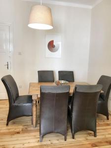 una sala da pranzo con tavolo e sedie in pelle di Charming Apartment Sofia 100m² a Sofia
