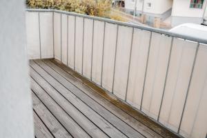 une terrasse en bois avec une clôture sur un bâtiment dans l'établissement Smart & Stay Living, à Mörlenbach