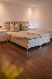 Cette chambre comprend un grand lit et du parquet. dans l'établissement Smart & Stay Living, à Mörlenbach