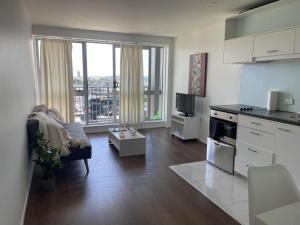 a kitchen and living room with a view of a city at Auckland city central apartment 2 bedrooms apartment Wi-Fi balcony harbor or skytower view near public parking 1204 in Auckland