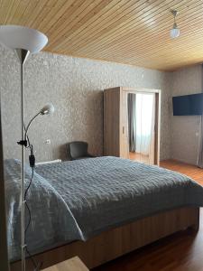 una camera da letto con un letto grande con soffitto in legno di Mestiakhedi a Mestia