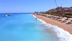 a beach with chairs and umbrellas and the ocean at IL Monte panoramic see view chalet in Ain Sokhna
