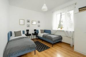 a bedroom with a bed and a couch and a window at Spacious House with Balcony Ideal for Families by Noclegi Renters in Poznań