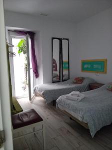 a bedroom with two beds and a mirror on the wall at APARTAMENTO VEEDOR 19 DÍAS Y MUCHAS NOCHES in Cádiz