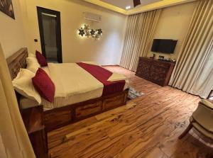 een slaapkamer met een bed en een flatscreen-tv bij Ranthambhore Bunglow in Sawāi Mādhopur