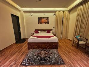 een slaapkamer met een bed, een bank en een stoel bij Ranthambhore Bunglow in Sawāi Mādhopur