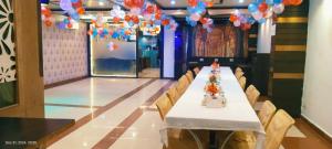 a long table with chairs in a room with balloons at Hotel Marygold in Agra