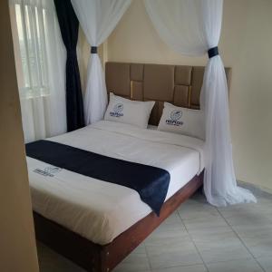 a bed in a room with white drapes at Frepego Lakeview Resort in Mbita
