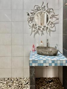 un bagno con lavandino e specchio di Authentic Bungalow for ocean lovers! a Tanah Lot Altre 37 foto