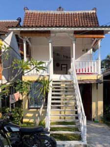 una casa bianca con delle scale davanti di Authentic Bungalow for ocean lovers! a Tanah Lot