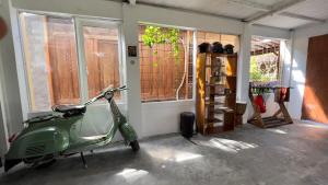 uno scooter verde parcheggiato in una stanza con finestre di Authentic Bungalow for ocean lovers! a Tanah Lot