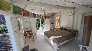 una camera da letto con un letto e un tavolo in una stanza di Authentic Bungalow for ocean lovers! a Tanah Lot