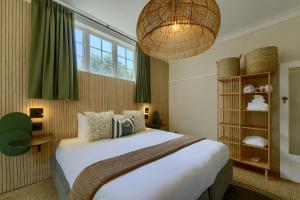 a bedroom with a large bed and a chandelier at Stoep By Ideas Cartel in Kalk Bay