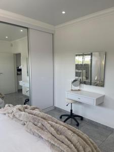a bedroom with a white desk and a mirror at Giftly Surprize in Kimberley