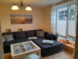 a living room with a blue couch and a table at FeWo Lena in Hanerau-Hademarschen