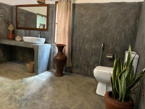 a bathroom with a sink and a toilet and a mirror at Anestwella in Tangalle