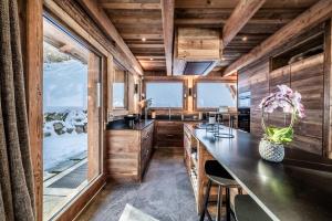 a kitchen with wooden walls and a large window at Chalet Betula, Saint-Gervais - by EMERALD STAY in Saint-Gervais-les-Bains