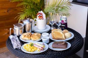 a black table with plates of breakfast food on it at Florence Motel - Santo Ângelo-RS in Santo Ângelo