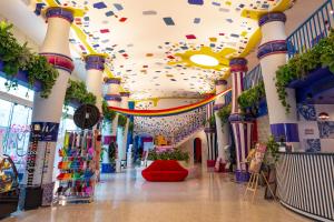 a hallway in a shopping mall with confetti ceilings at The Fig Lobby Bangkok in Bangkok