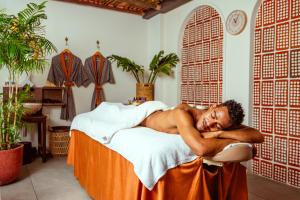 a man laying on a bed in a room at The Fig Lobby Bangkok in Bangkok