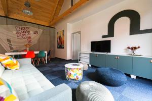 a living room with a couch and a tv at Soling apartmanház Velence in Velence