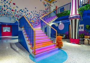 a staircase in a room with colorful stairs at The Fig Lobby Bangkok in Bangkok