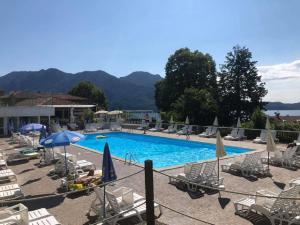 a large swimming pool with chairs and umbrellas at Bella Rosa in Ghiffa