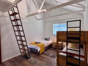 a bedroom with a bunk bed and a ladder at Kiekiebos in Wilderness