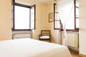 a bedroom with a bed and two windows at Il Viandante in Santo Stefano di Magra