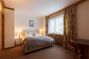Postel nebo postele na pokoji v ubytování Hotel Europa Suites St Moritz