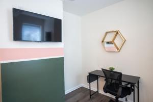 Habitación con escritorio, espejo y silla. en Diamond Suites Philadelphia Center, en Filadelfia 19 fotos más