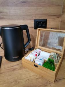 una taza negra sentada junto a una caja de madera con toallas en Stephany LUX Apartment, en Ruse