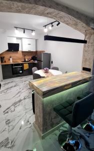 cocina y sala de estar con barra y silla en Stephany LUX Apartment, en Ruse