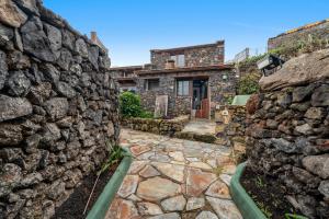 a stone house with a stone wall at Tesbabo Rural - Camelia in Mocanal