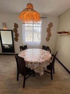 a dining room table with chairs and a chandelier at Appartement Lili in Grand-Baie