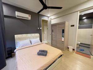 a bedroom with a bed with two towels on it at NR Cyber1 Homestay in Cyberjaya