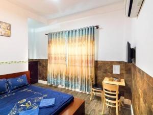 a bedroom with a bed and a table and a desk at Hoàng Bách 3 Hotel in Ho Chi Minh City