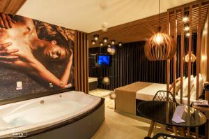a bathroom with a bath tub and a bedroom at Florence Motel - Santo Ângelo-RS in Santo Ângelo +58 photos