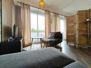 a bedroom with a bed and a chair and a table at Studio Cosy AspinIII in Pau