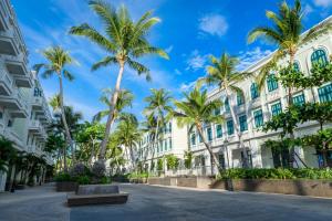 a street in front of a building with palm trees at Meridian apartment service at Marina Long beach Phu Quoc in Phú Quốc