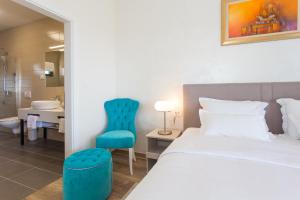 a bedroom with a bed and a blue chair at Villa Lemon Tree in Vinišće