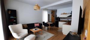 a living room with a couch and chairs and a kitchen at Villa Erdődy Resort - Apartman 18 in Oravská Lesná