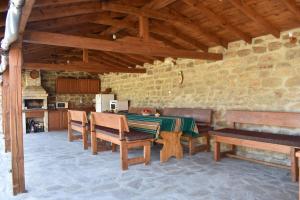 a kitchen with a table and benches in a room at Коларова къща in Avren