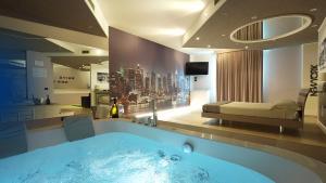 a bathroom with a bath tub with a bed in the background at Motel Soignè in Mapello