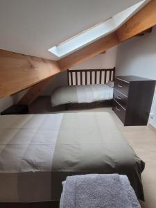 a attic bedroom with two beds and a skylight at L 'appart de la volane in Vals-les-Bains +2 photos